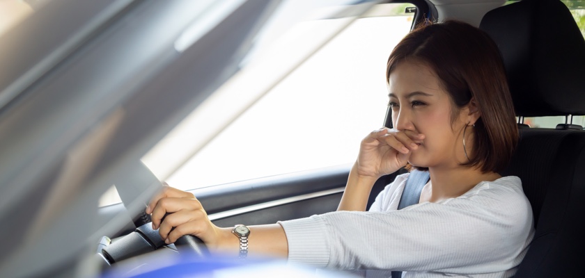 Driver covering nose to avoid car smells