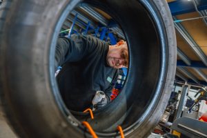 Mr Tyre Rochdale mechanic seen through the centre of a tyre